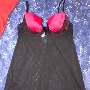 Black mesh babydoll lingerie with lace detailing, a black bow, and red cups.